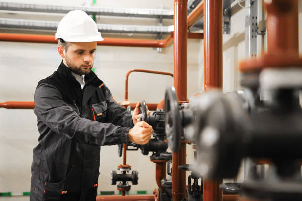 modern factory worker turning valve. industrial engineer on oil plant